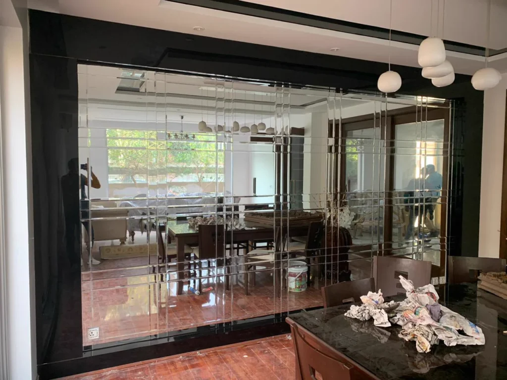 Floor-to-ceiling mirror glass partition wall with black framing in a dining room